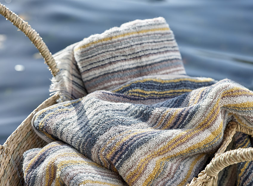 Gestreifte Handtücher in einem Korb am See